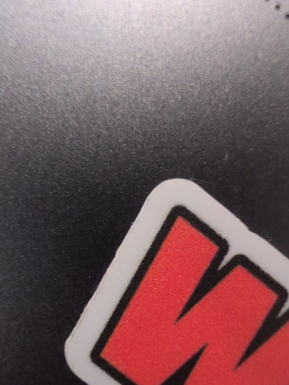 Red Letter Sticker on Black Surface